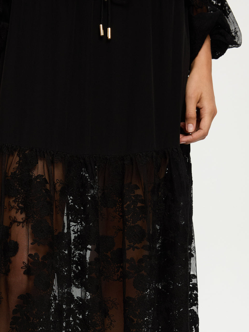 Black dress with floral lace details on a white background