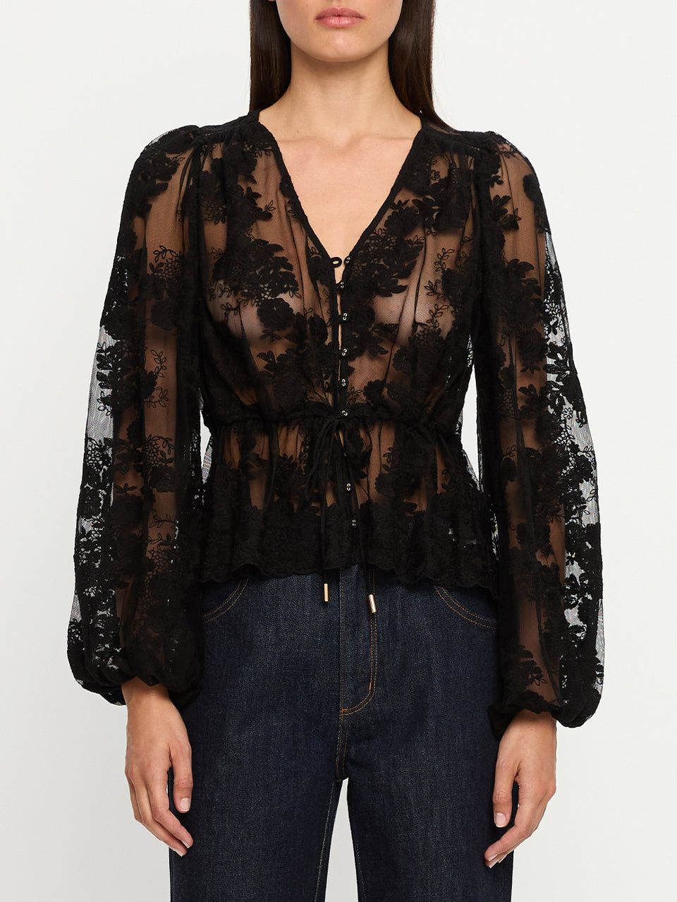 Black lace blouse worn by a person on a white background