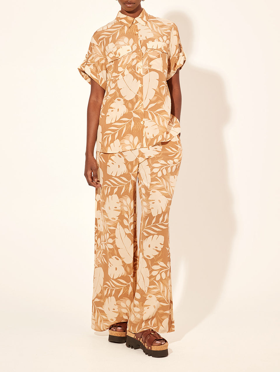 Cove Pant KIVARI | Model wears neutral coloured leaf printed pant