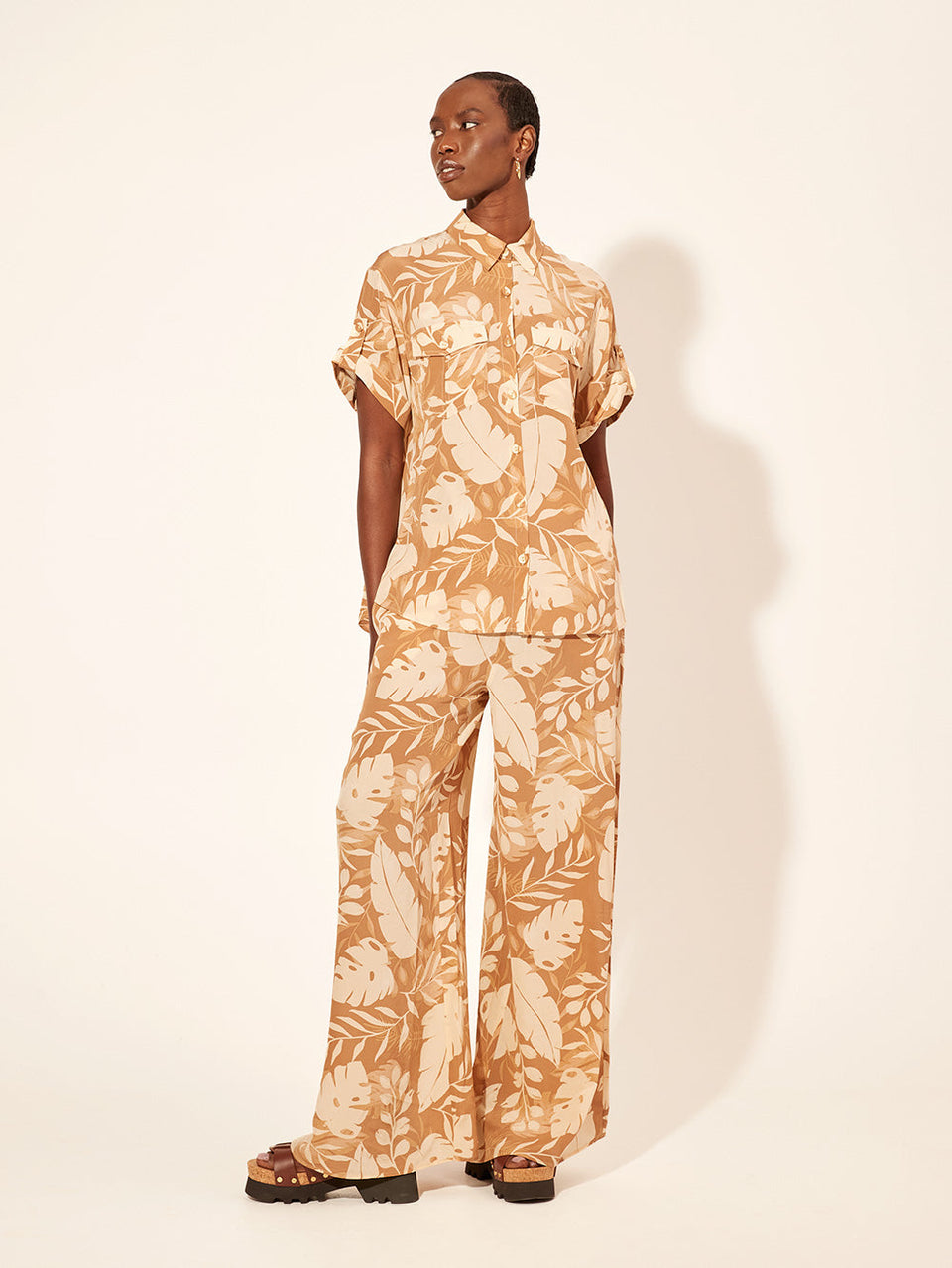 Cove Pant KIVARI | Model wears neutral coloured leaf printed pant