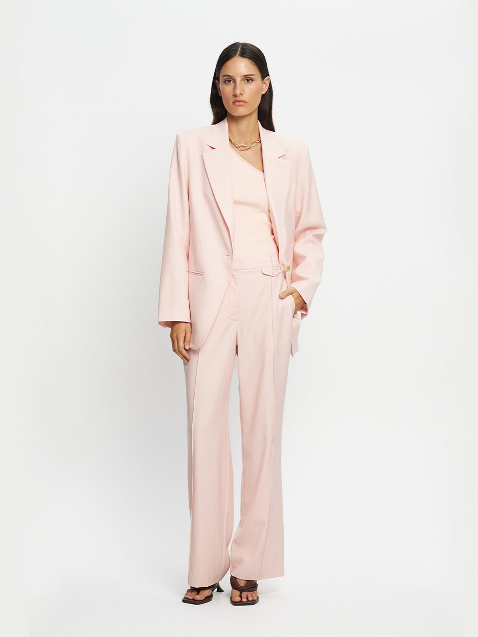 Woman wearing a light pink suit on a white background