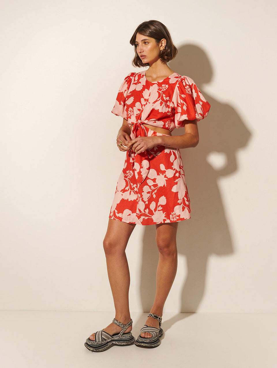 Delfina Mini Dress KIVARI | Model wears pink and red floral mini dress side view