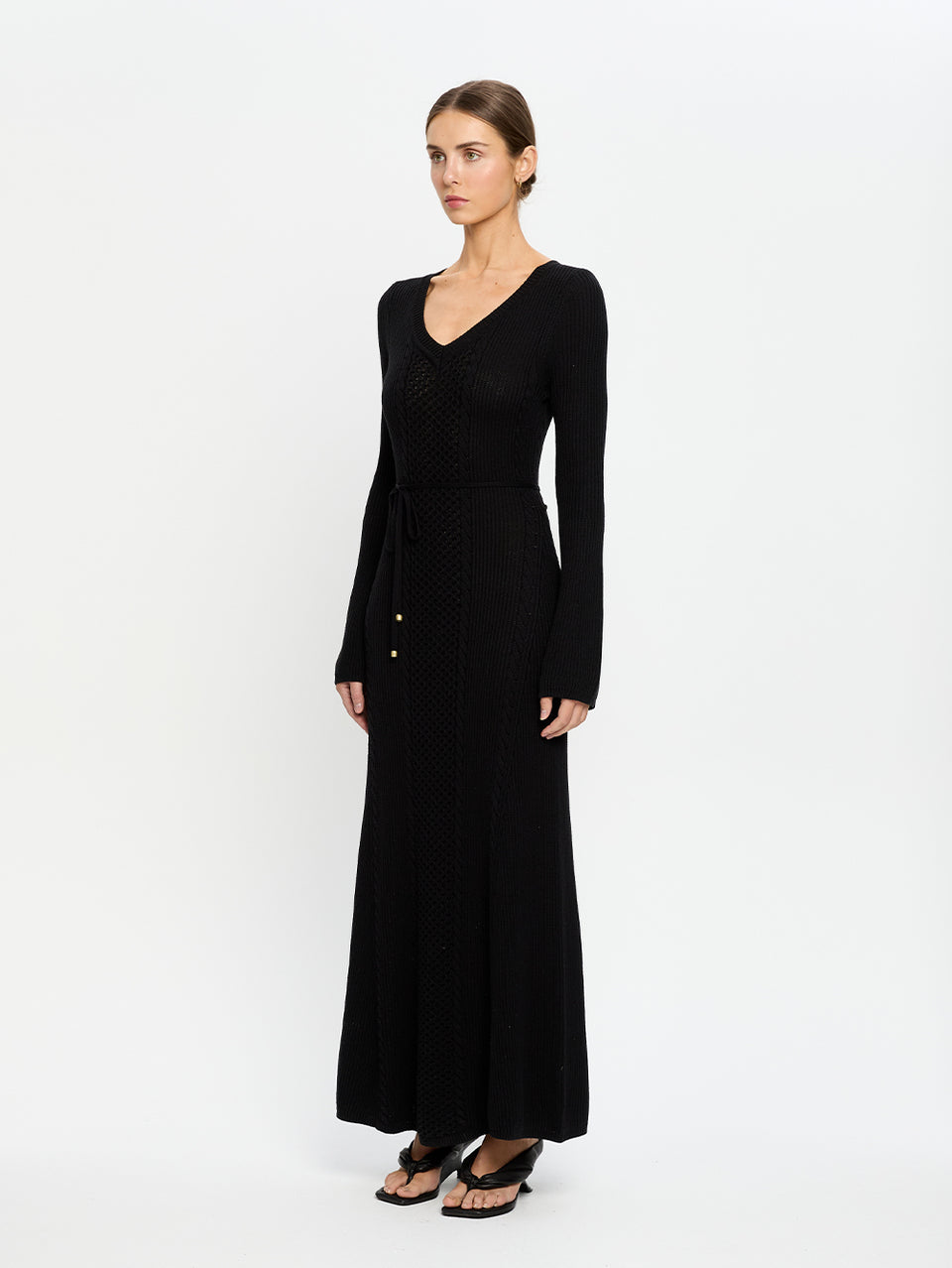 Woman wearing a black long-sleeve dress on a white background