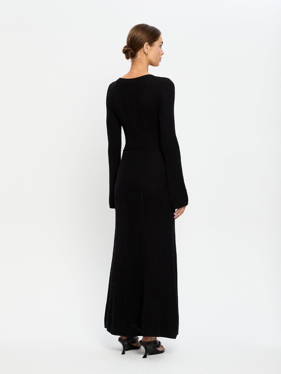Woman wearing a black long-sleeve dress on a white background