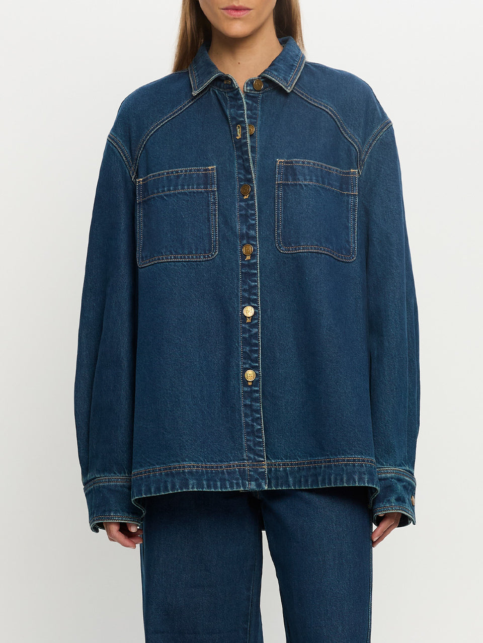 Person wearing a blue denim jacket on a white background