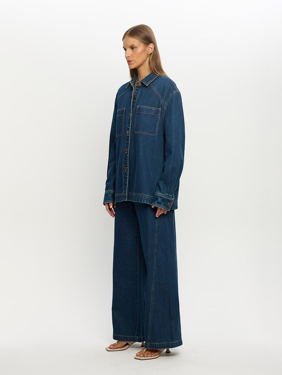 Woman wearing a blue denim outfit on a white background