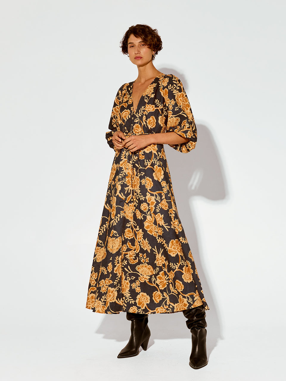 Kaia Maxi Dress KIVARI | Model wears orange and black floral maxi dress side view