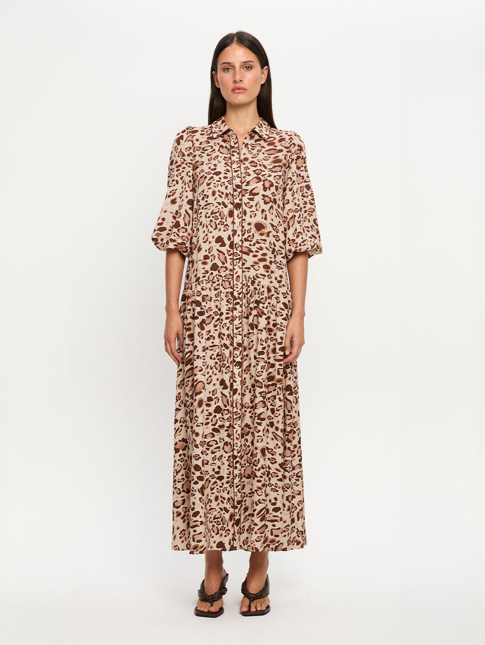 Woman wearing a leopard print dress on a white background