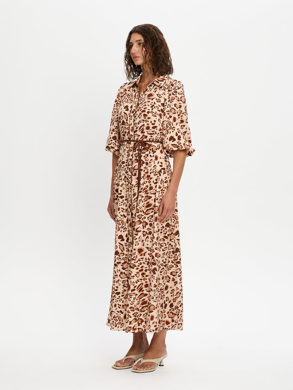Woman wearing a leopard print dress on a white background