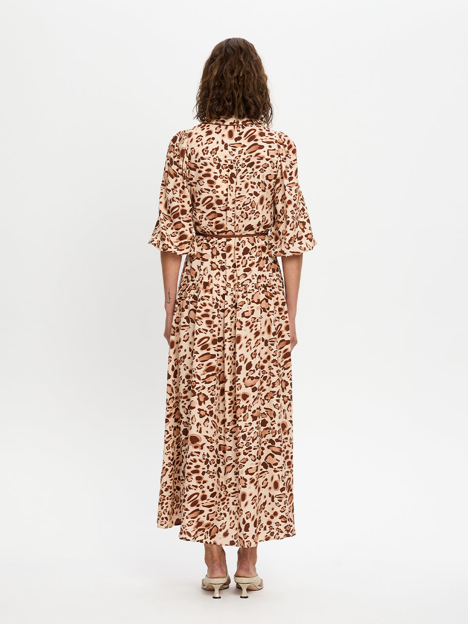 Woman wearing a leopard print dress on a white background