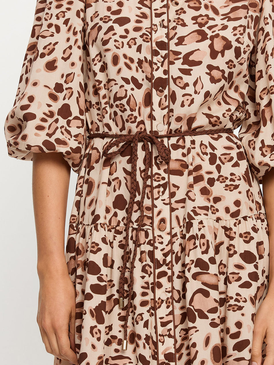 Leopard print dress with a tie waist on a plain background