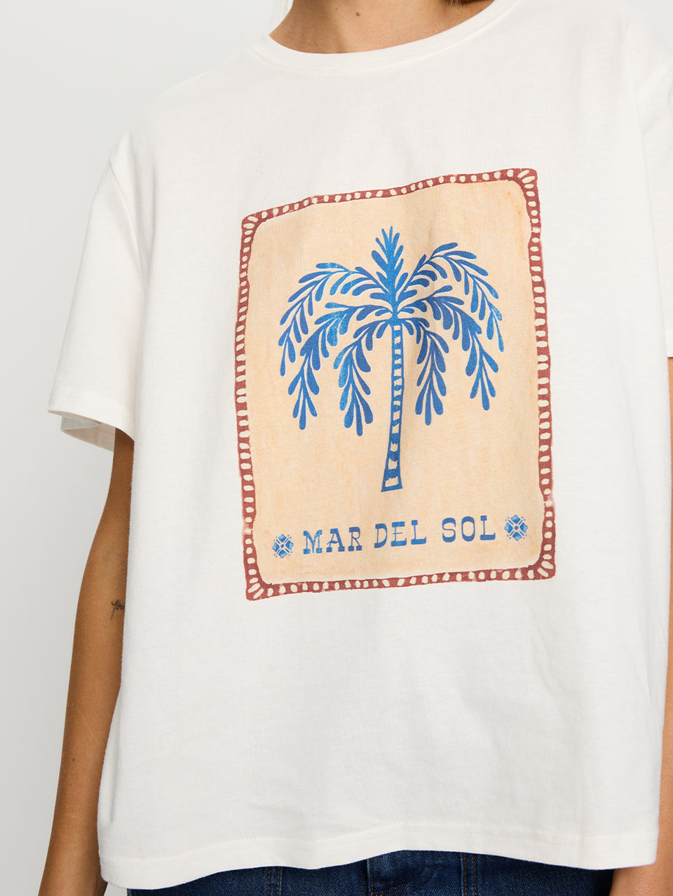 Sol Tee KIVARI | Model wears tee shirt with palm tree print close up