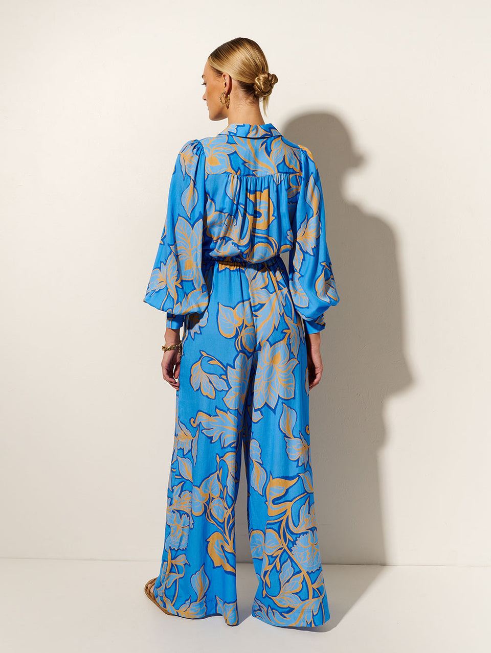 Taniana Jumpsuit KIVARI | Model wears blue and orange floral jumpsuit back view