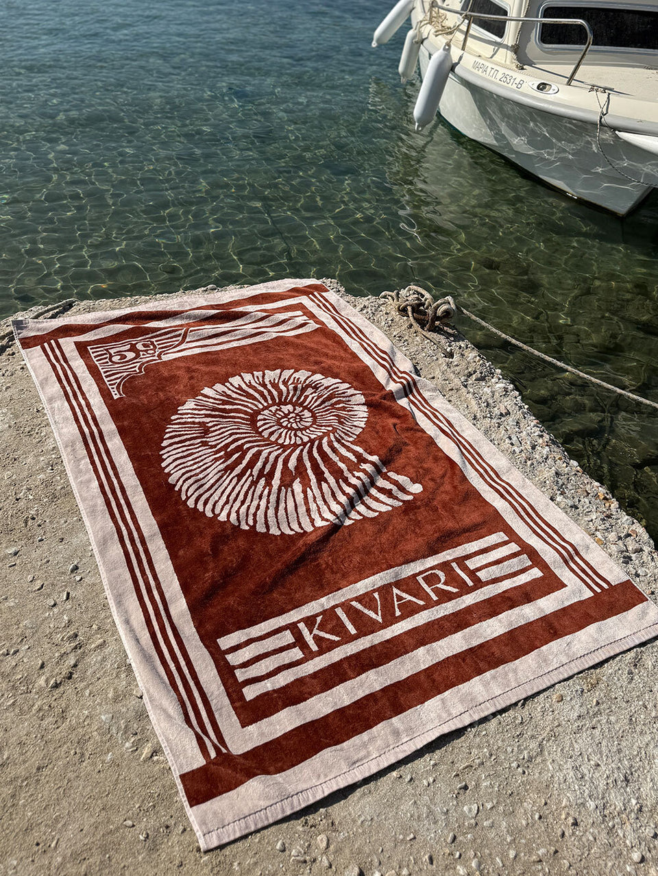 Kivari towel with shell design by water