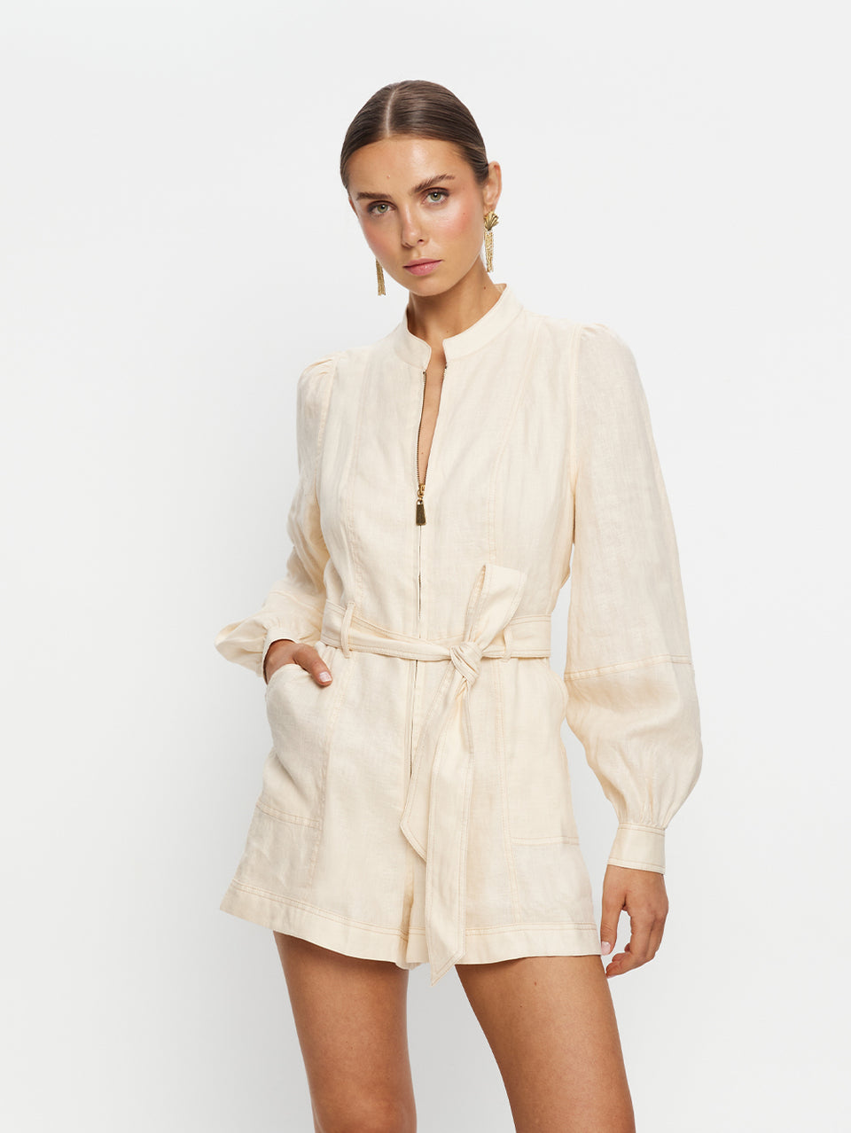 Woman wearing a beige romper on a white background