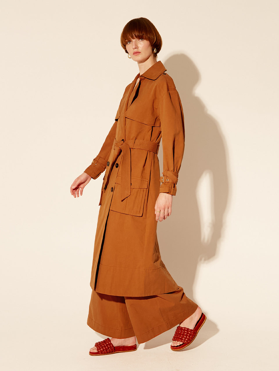 Carolina Trench Coat KIVARI | Model wears burnt orange trench coat side view