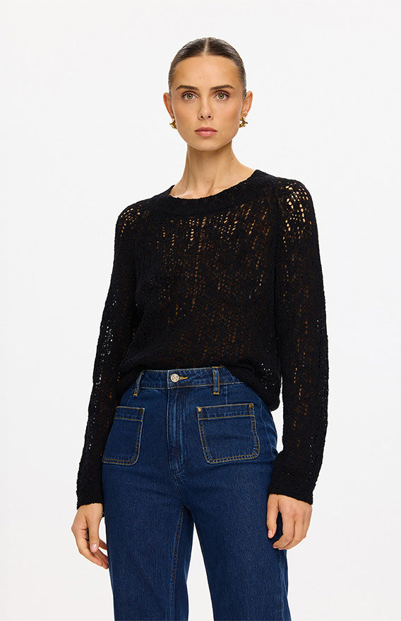 KIVARI categories image - model wearing black open-knit long-sleeve sweater with blue wide-leg denim jeans
