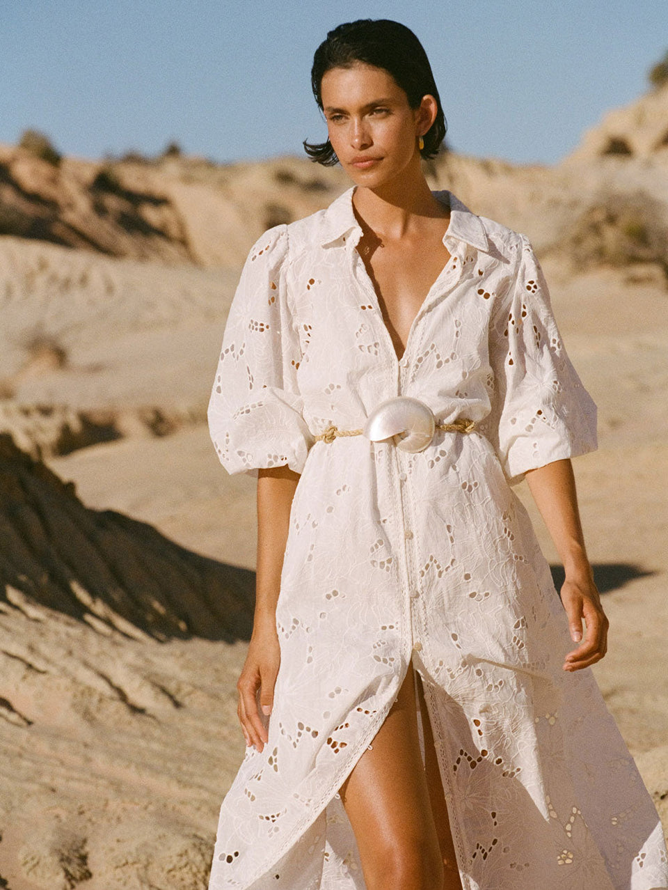 KIVARI Corfu Midi Dress | Model wearing White Midi Dress in front of rocks