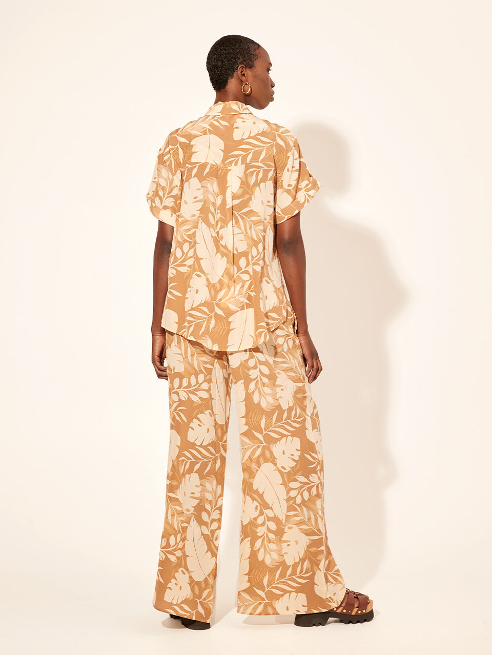 Cove Pant KIVARI | Model wears neutral coloured leaf printed pant back view