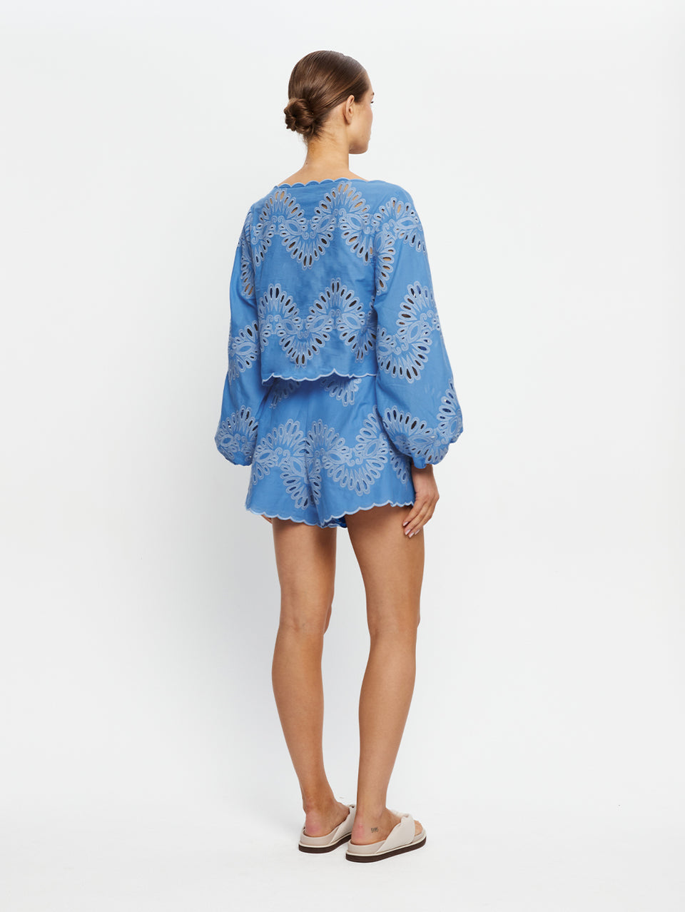 Woman wearing a blue embroidered set on a white background