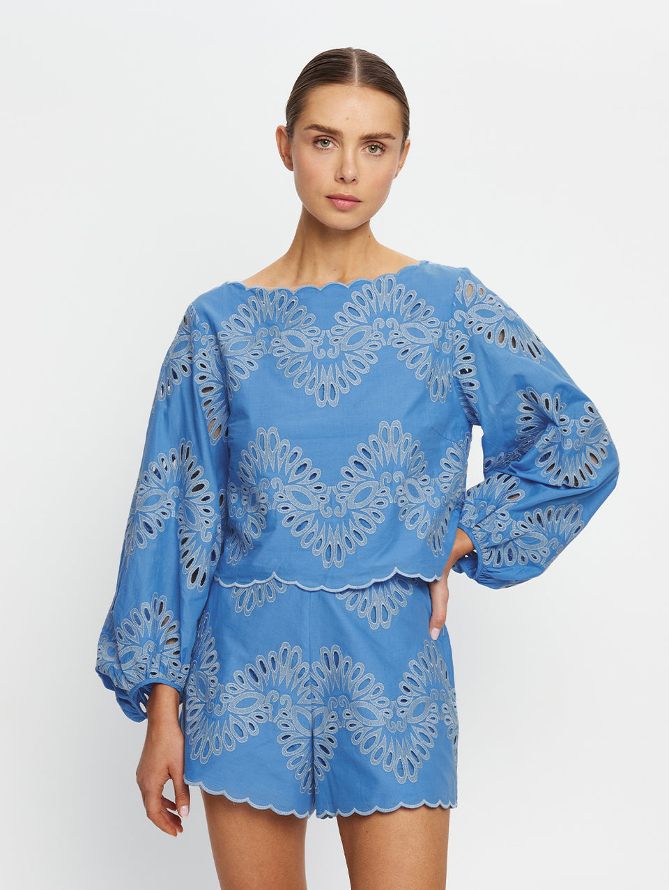 Woman wearing a blue embroidered set on a white background