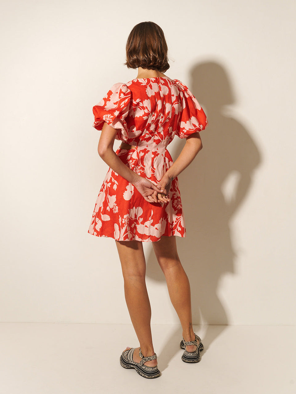 Delfina Mini Dress KIVARI | Model wears pink and red floral mini dress back view