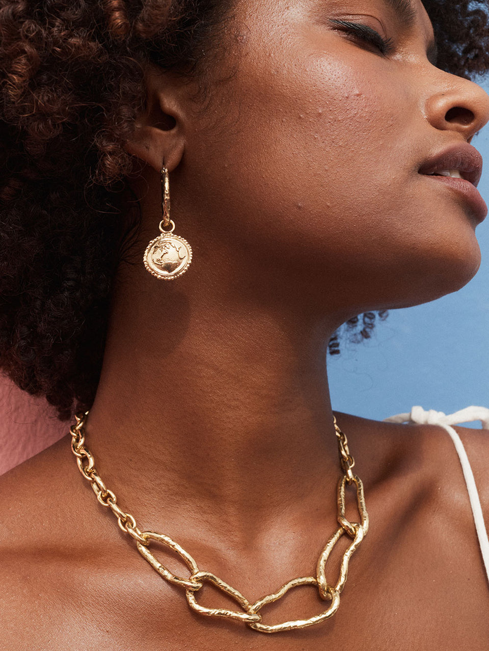 Discovery Hoop Earrings KIVARI | Model wears small gold hoop earrings with drop down pendant