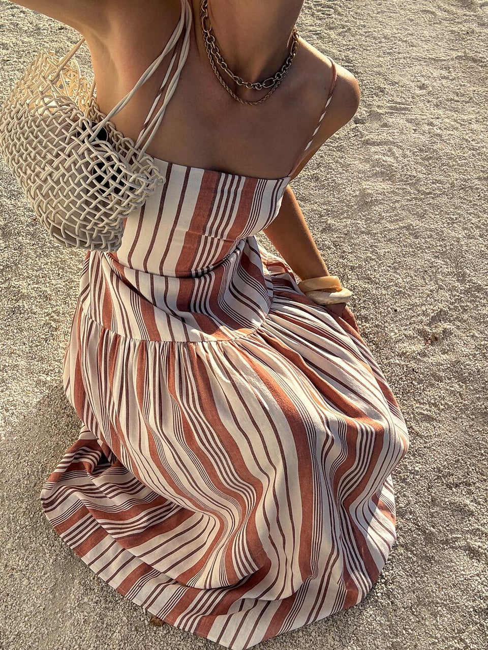 Woman in a striped dress on a sandy beach