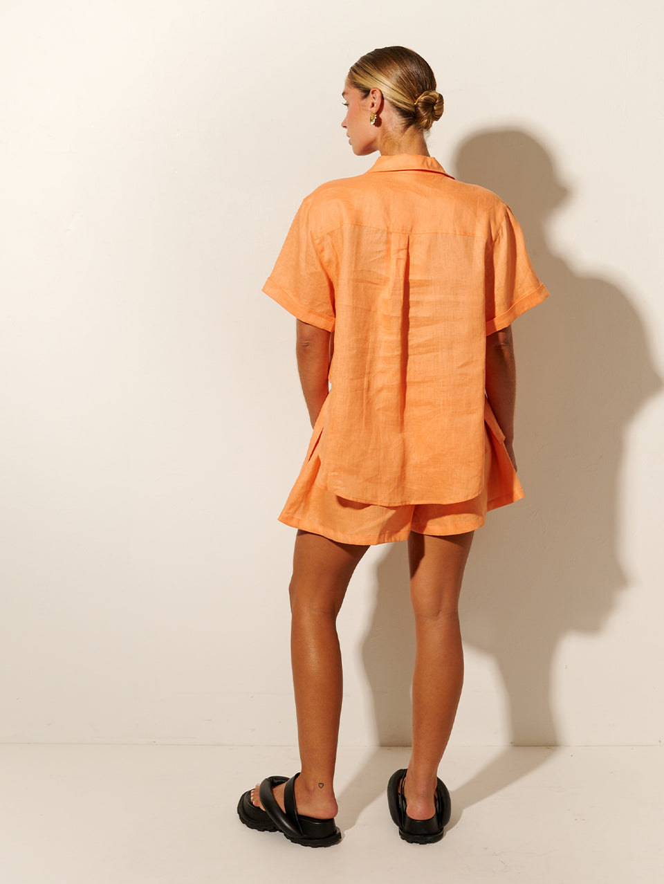 KIVARI Jacana Short | Model wears Orange Shorts Back View