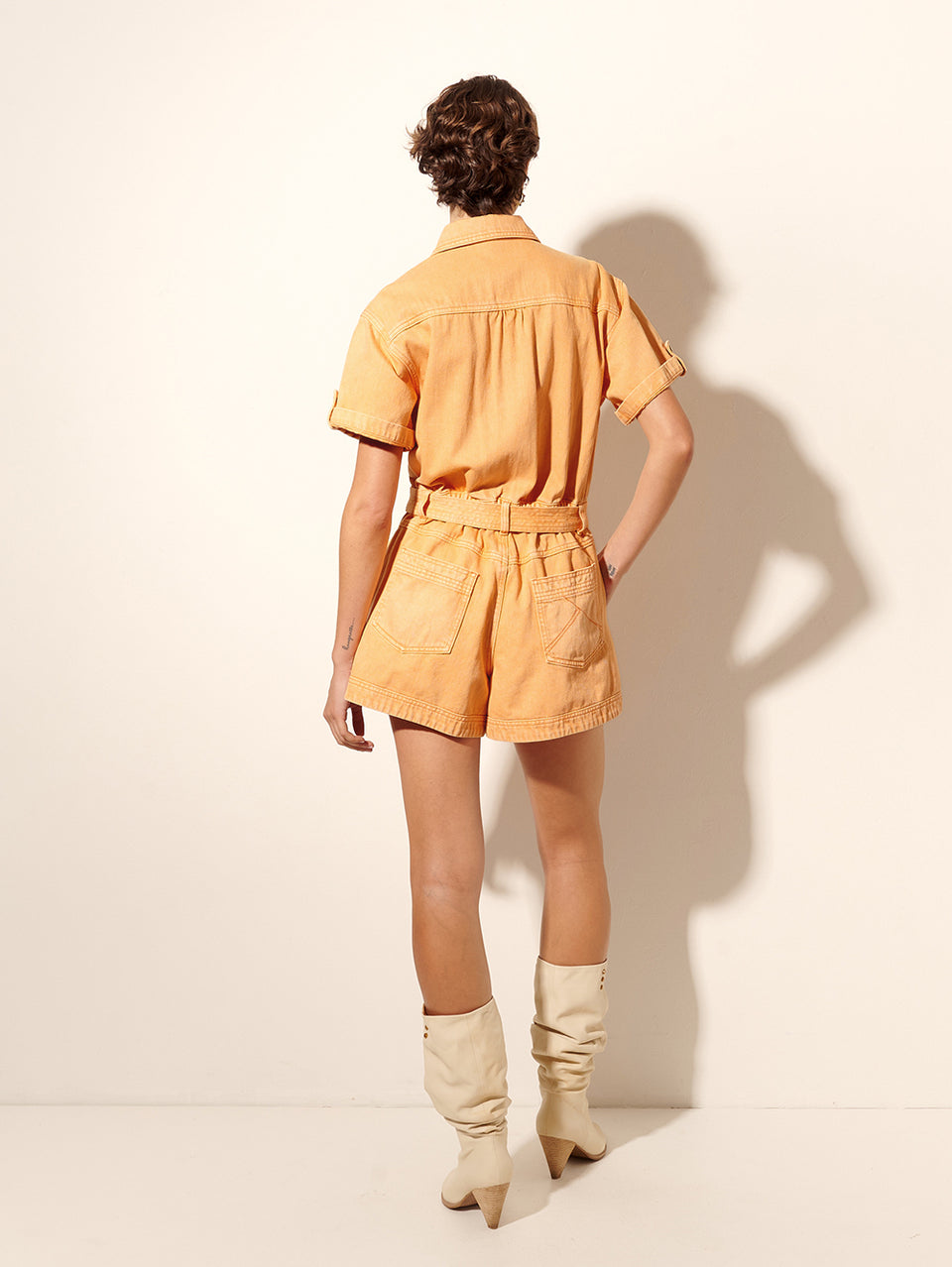 Georgie Playsuit Peach KIVARI | Model wears orange denim playsuit back view