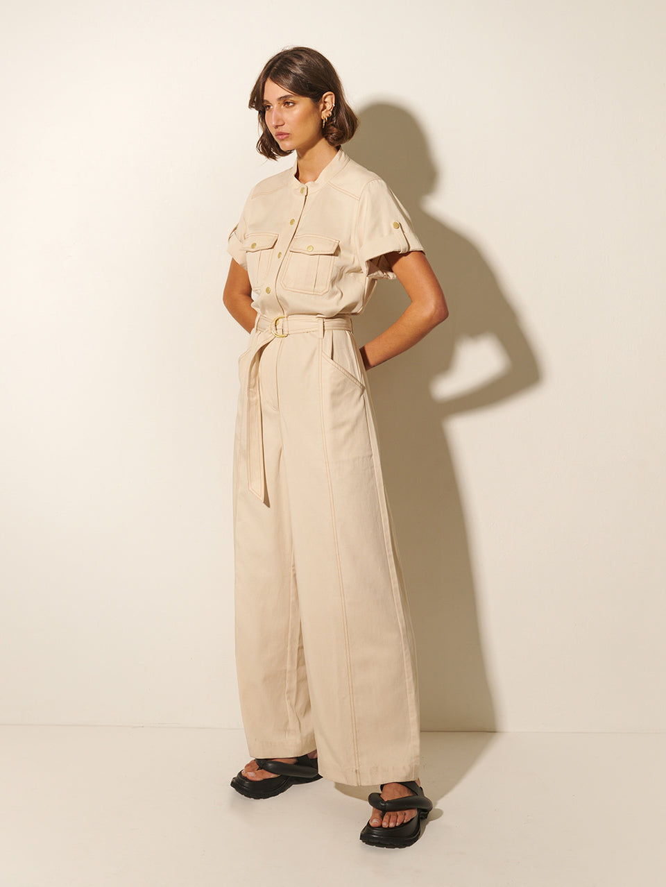 Gianna Jumpsuit KIVARI | Model wears cream short sleeve jumpsuit side view