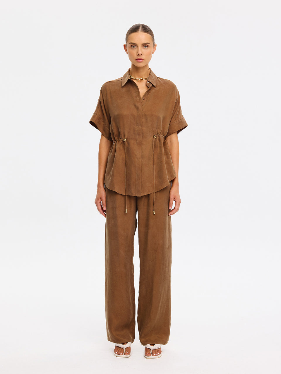 Woman wearing a brown outfit on a white background