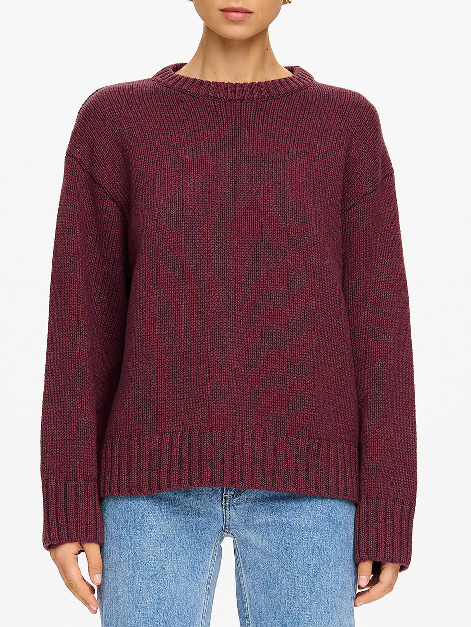 KIVARI Odette Crew Neck Jumper in Plum – close-up torso detail of women's dark plum ribbed knit crew neck sweater showing ribbed hem and sleeve cuffs with blue jeans