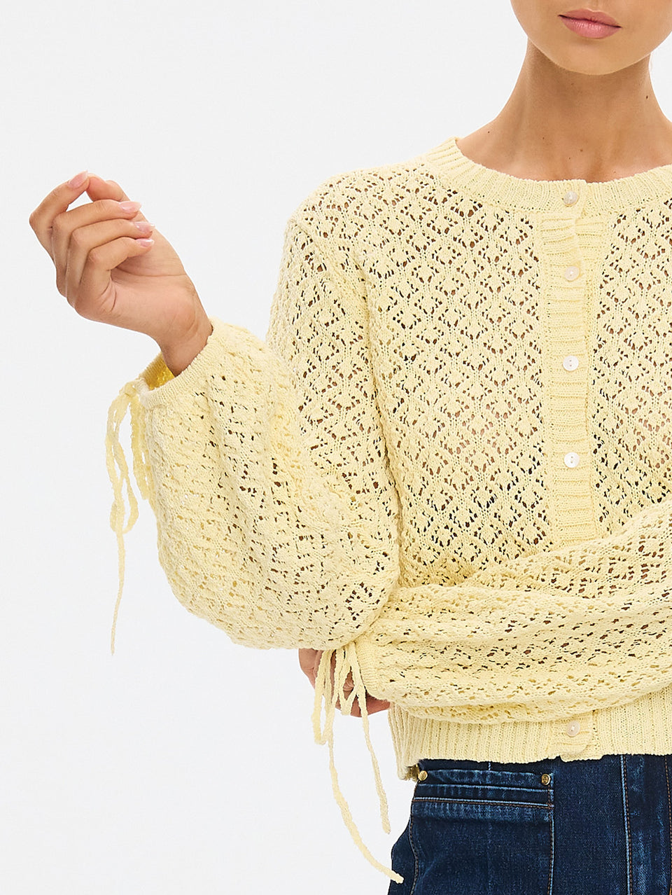 Sally Knit Cardigan in Butter yellow, close-up of open-knit cropped cardigan with voluminous sleeves and tie cuffs