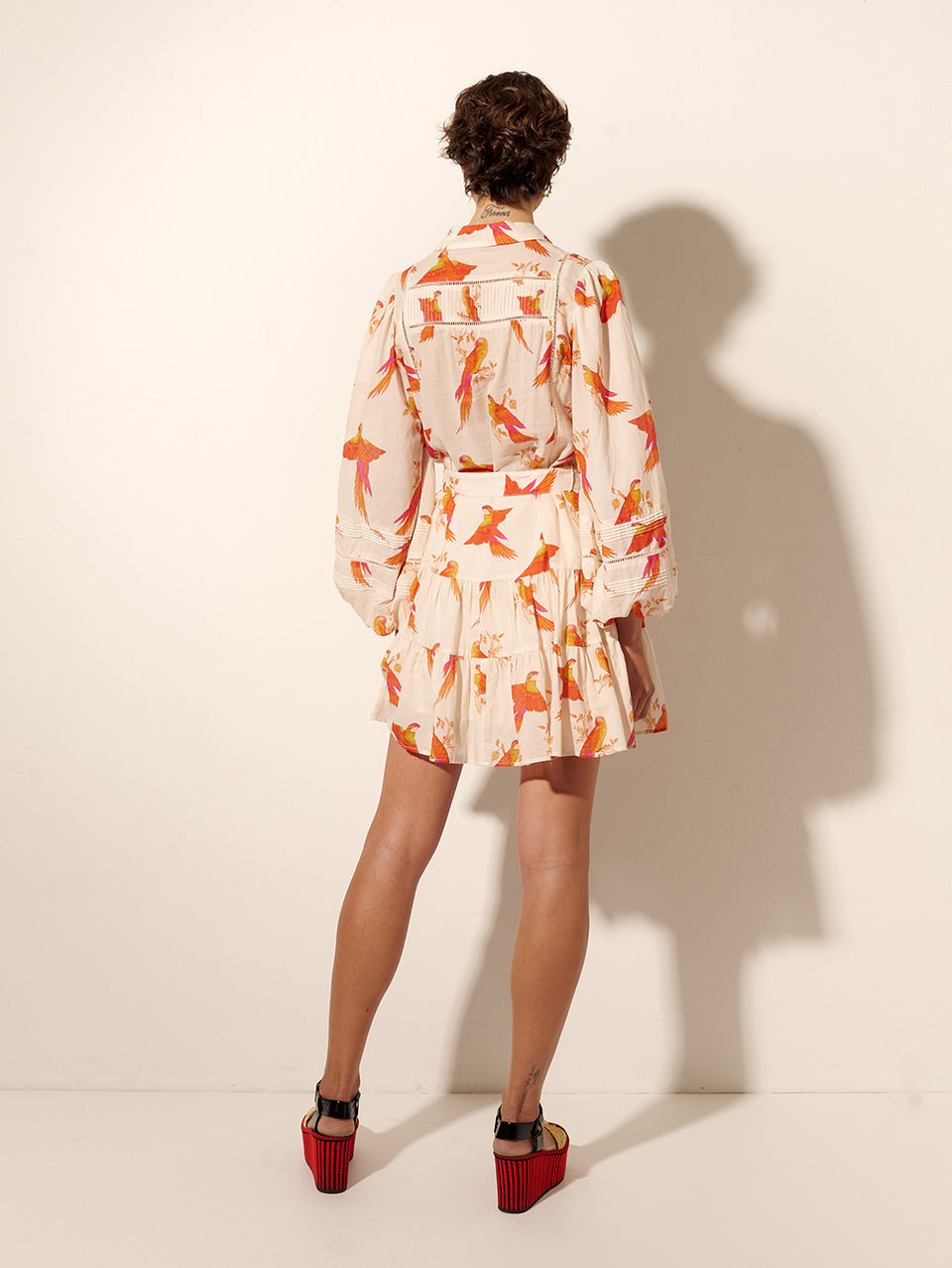 Kaylee Mini Dress KIVARI | Model wears pink and orange bird print mini dress back view