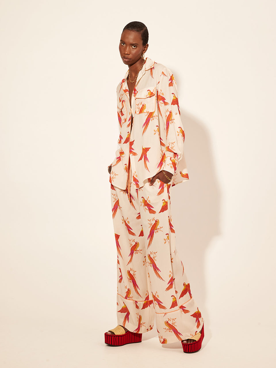 Kaylee Pant KIVARI | Model wears pink and orange bird printed pants side view