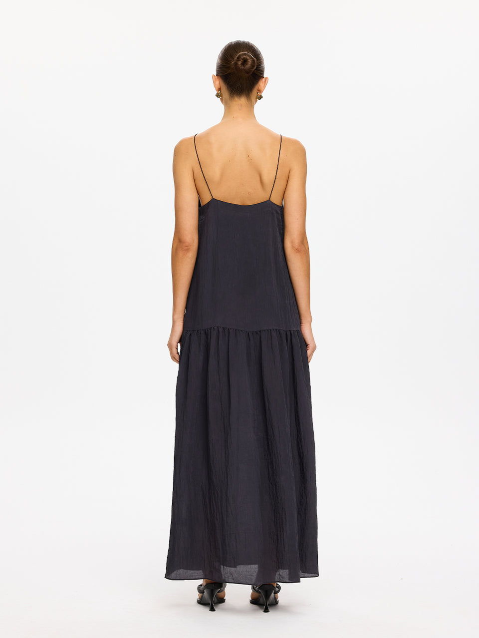 KIVARI Umi Maxi Dress in Charcoal – back view of model wearing women's charcoal spaghetti strap tiered maxi dress