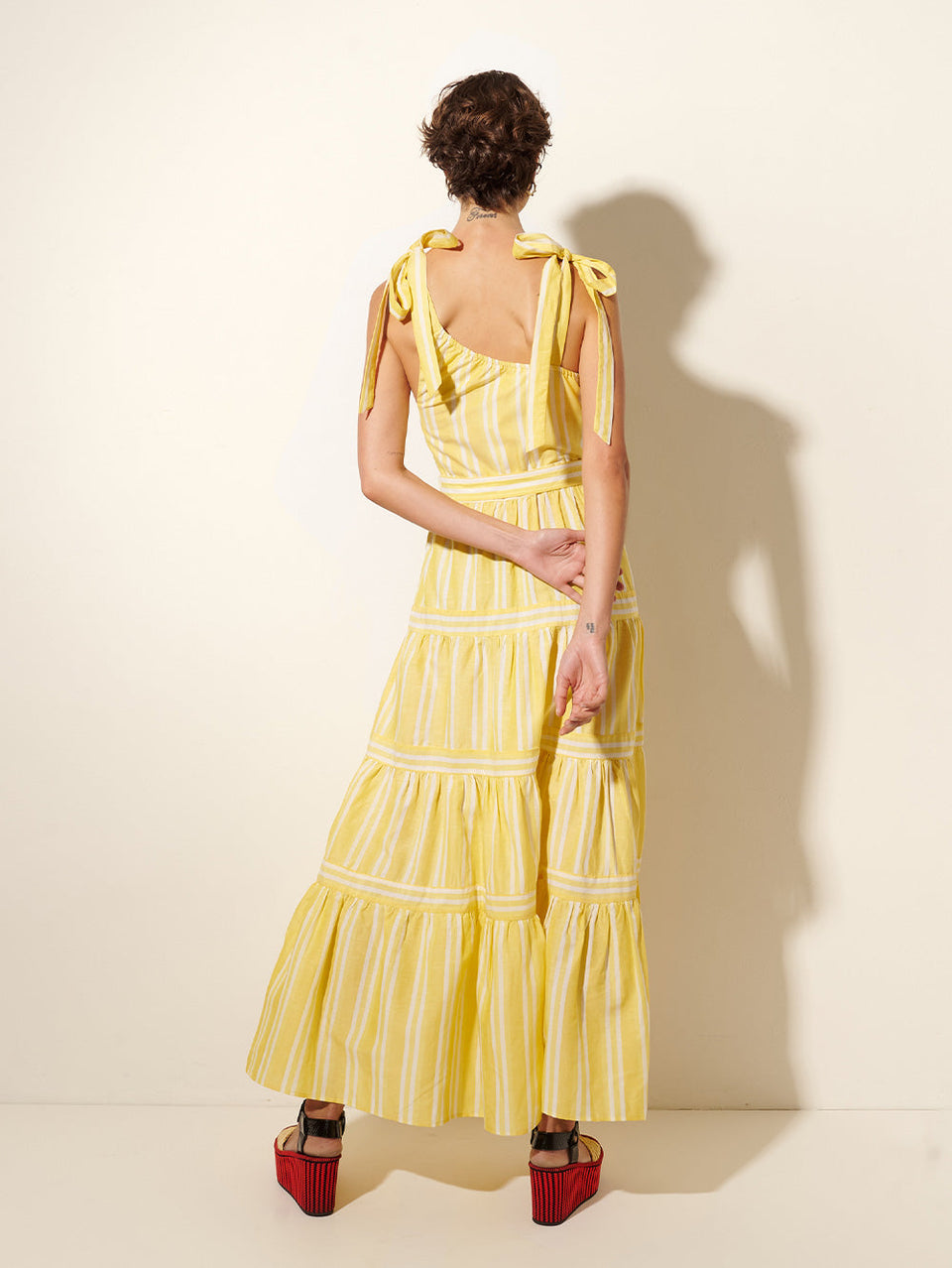 Lola Maxi Dress KIVARI | Model wears yellow and white striped maxi dress back view