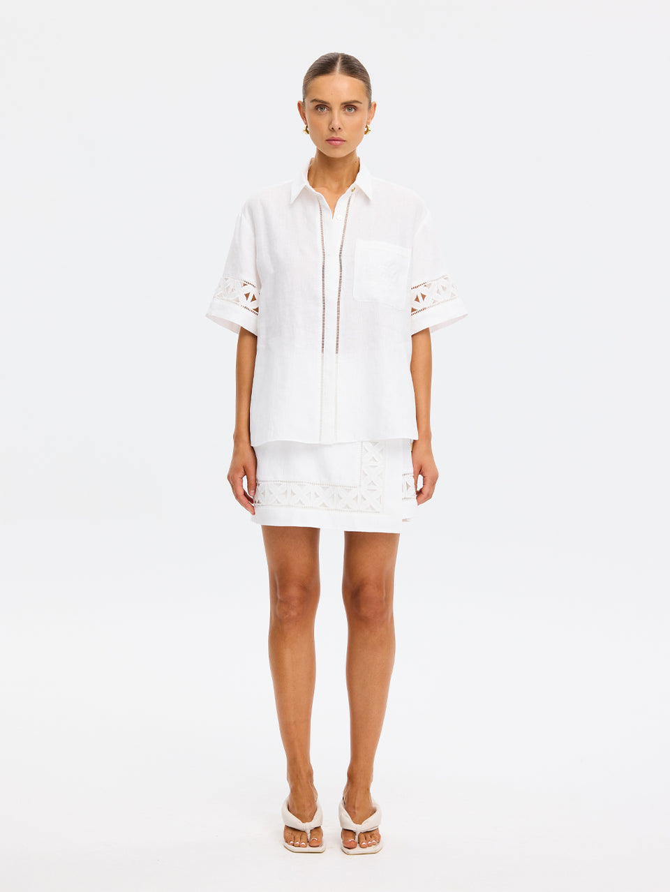 Woman wearing a white outfit on a plain background