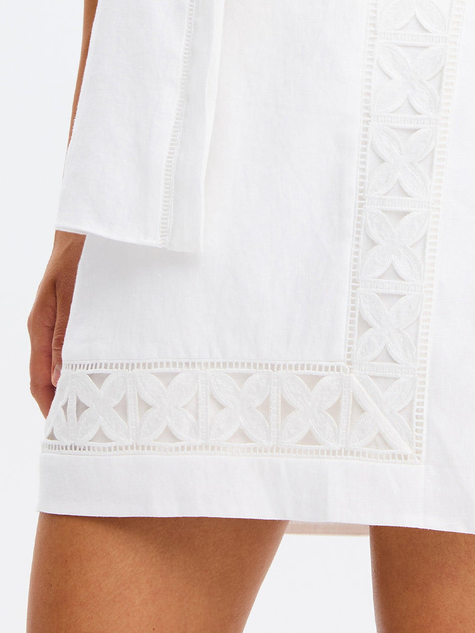 White dress with intricate lace detailing on a plain background