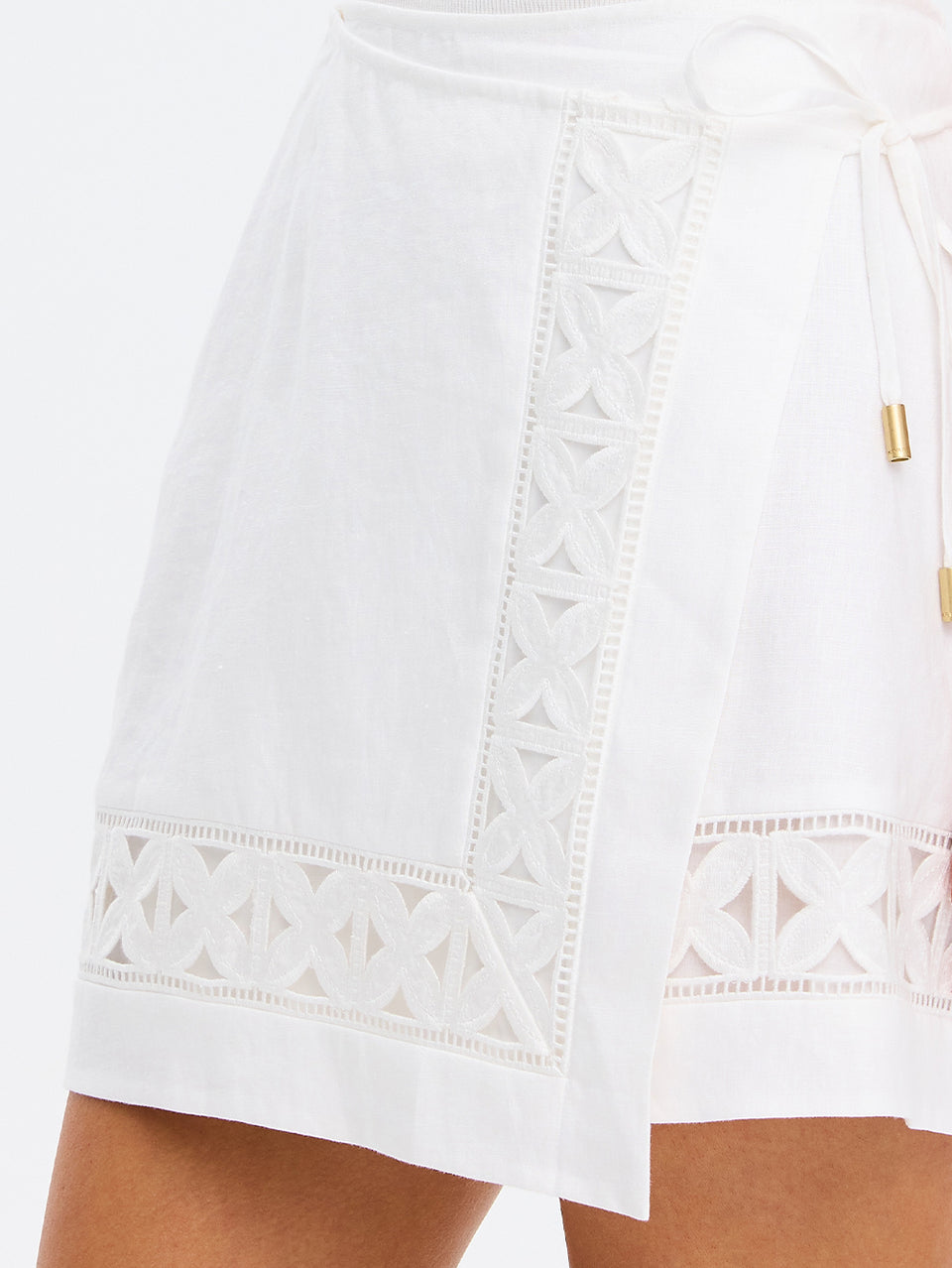 White lace-trimmed skirt with a gold zipper on a white background