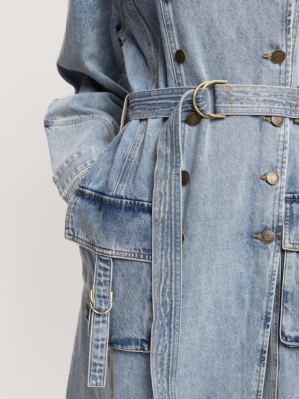 Olivia Denim Trench Coat KIVARI | Model wears light blue wash denim trench coat close up