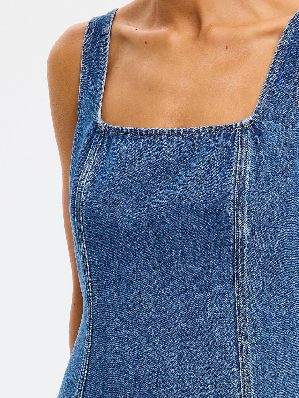 Close-up of a blue denim dress on a white background