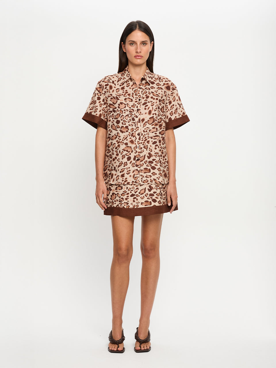 Woman wearing a leopard print shirt nd skirt on a white background