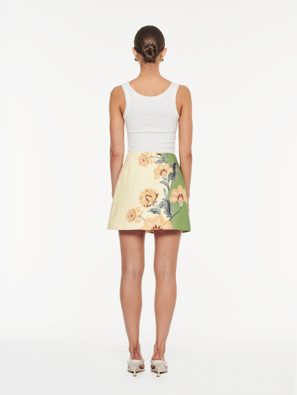 Lotte Mini Skirt in Green Cream, back view of A-line mini skirt with floral print and white tank top