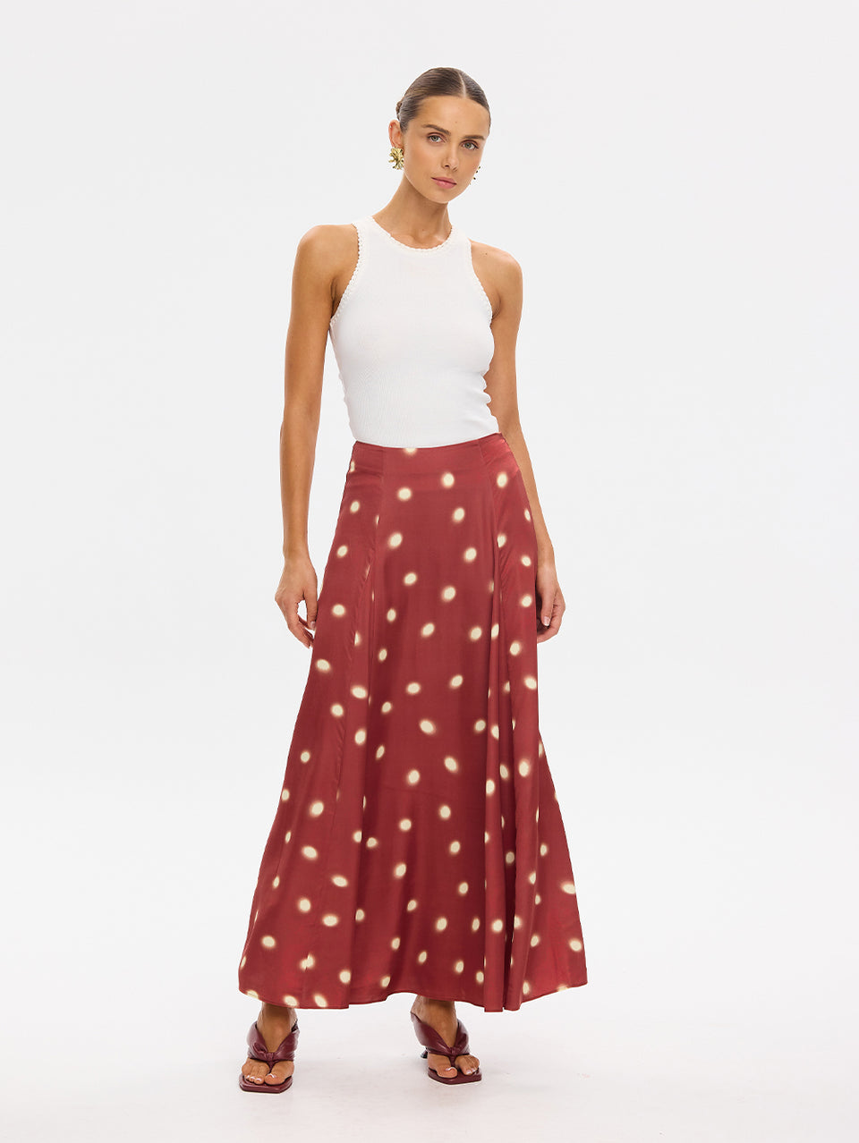 KIVARI Saro Maxi Skirt in Brick – polka dot maxi skirt styled with a white tank top, front view