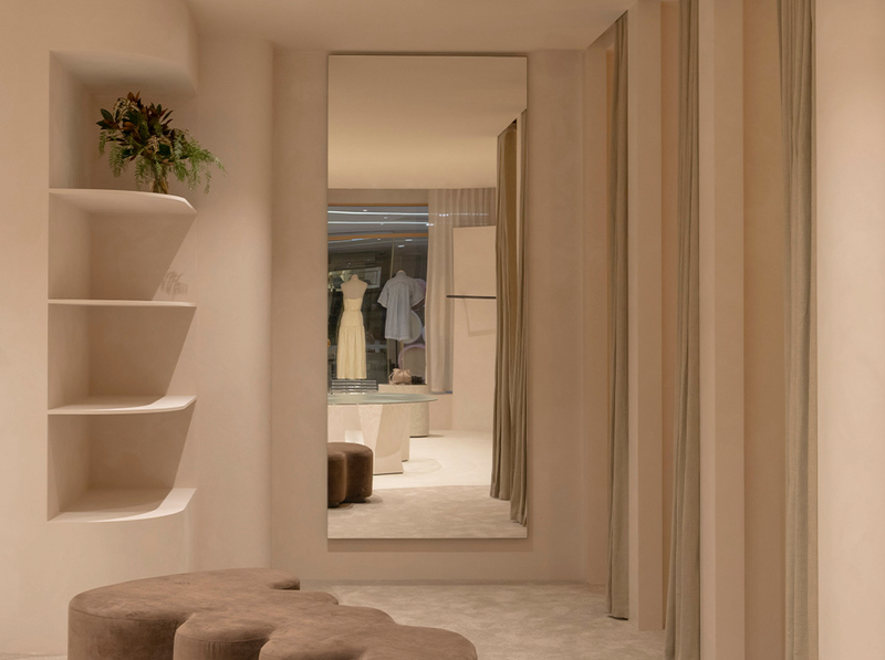 Modern interior design with a mirror reflecting clothing and decor elements.