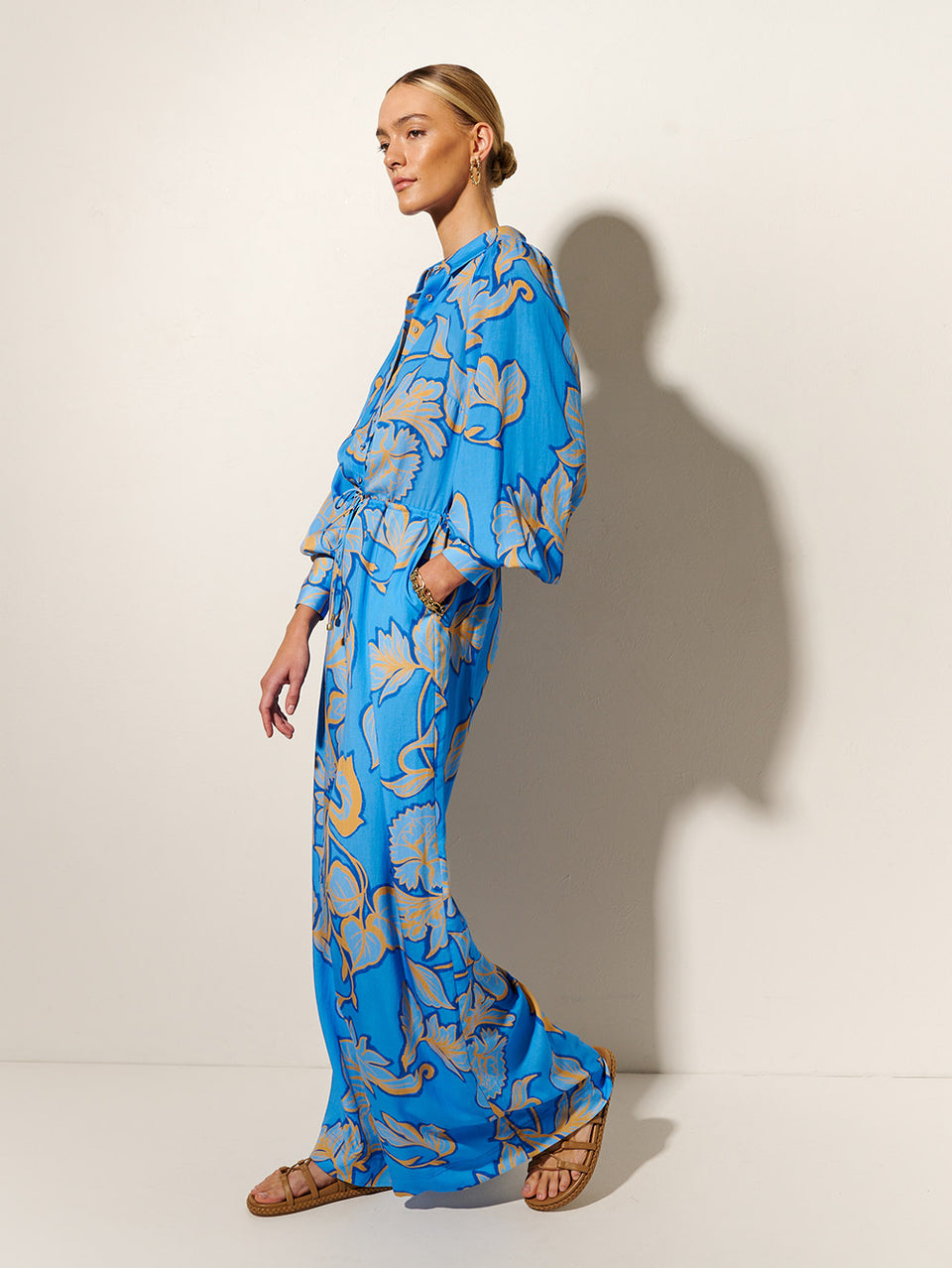 Taniana Jumpsuit KIVARI | Model wears blue and orange floral jumpsuit side view